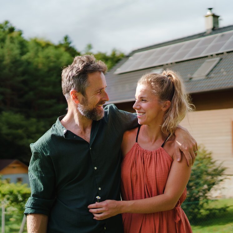 Ein Mann und eine Frau, die vor einem Haus stehen. 